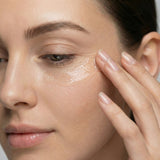 Woman applying freezeframe BOOST SERUM to the under-eye area