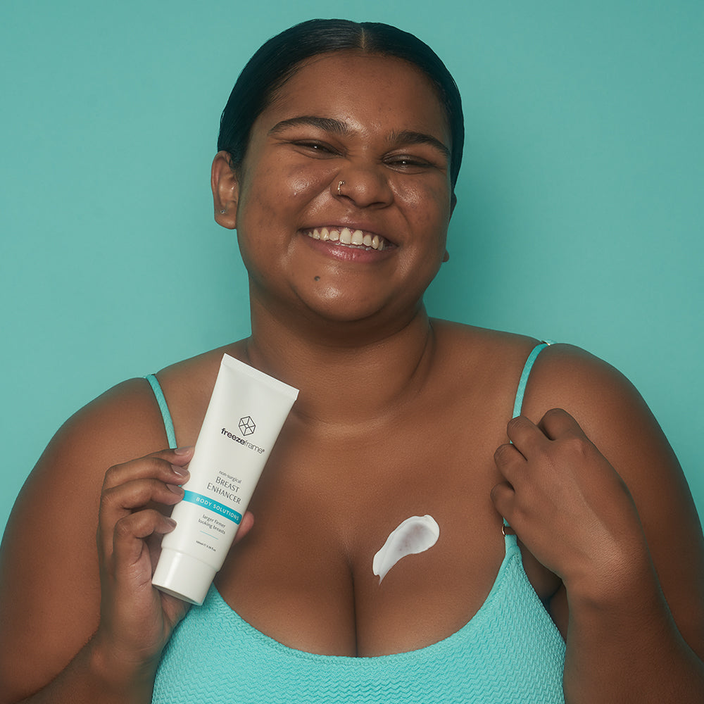 freezeframe BREAST ENHANCER cream texture applied to chest by woman holding product tube 