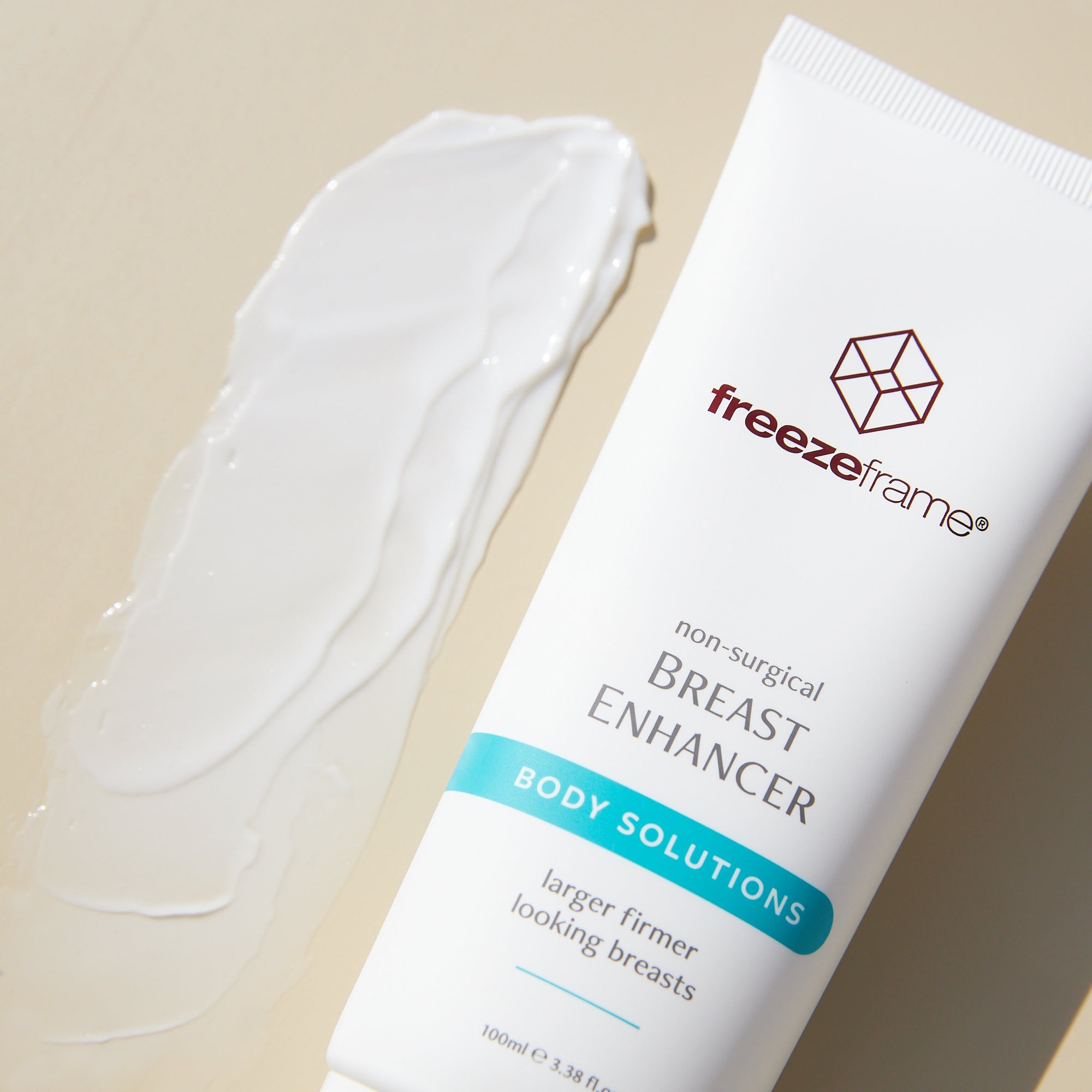 freezeframe BREAST ENHANCER cream texture next to product tube
