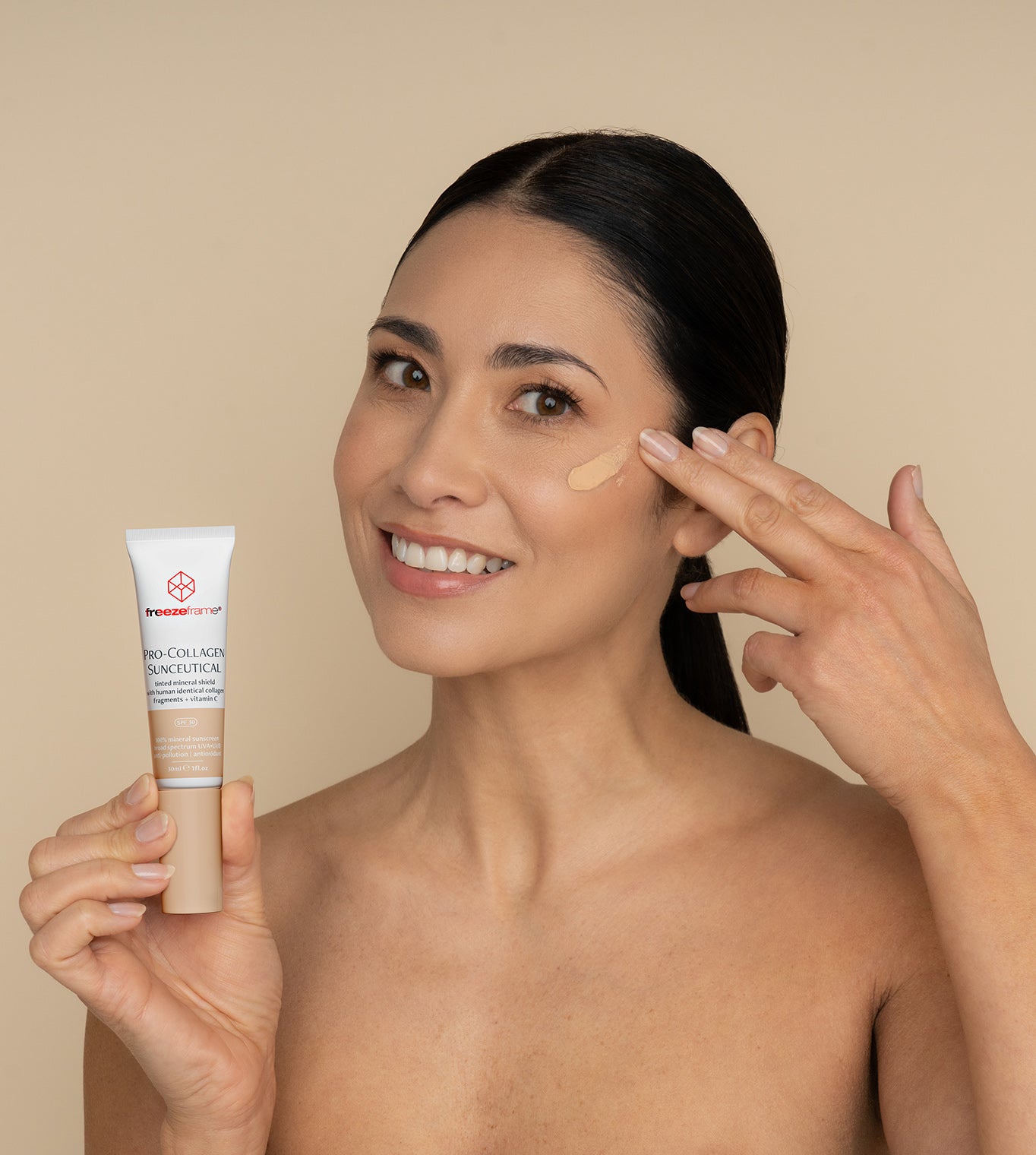 freezeframe PRO-COLLAGEN SUNCEUTICAL product applied to cheek by woman who is holding product tube, showing skin-perfecting finish