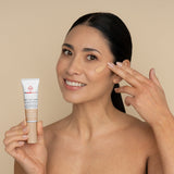 freezeframe PRO-COLLAGEN SUNCEUTICAL product applied to cheek by woman who is holding product tube, showing skin-perfecting finish