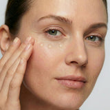 Woman applying freezeframe REVITALEYES gel treatment to the under-eye area