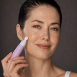 Woman holding FreezeFrame EYELID LIFT upper eyelid lifting serum with cooling ceramic massage applicator